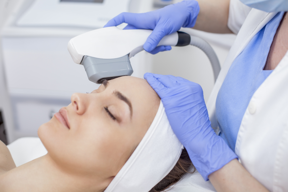 Woman having a Sofwave skin tightening ultrasound treatment performed on her face.